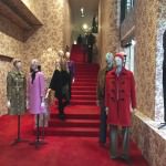 Paris opulenter Fashionstore mit rotem Treppenaufgang und dekorierten Puppen seitlich.